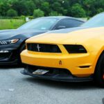 Mustang Auto - parked yellow Ford Mustang coupe and black
