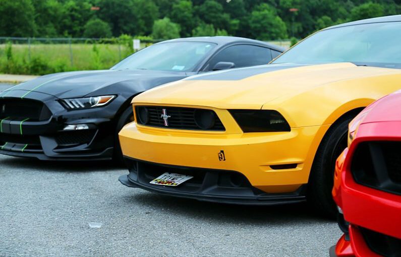 Mustang Auto - parked yellow Ford Mustang coupe and black