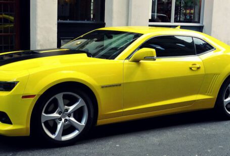 Mustang Auto - Yellow Chevroelt Camaro Parked Outside of Building