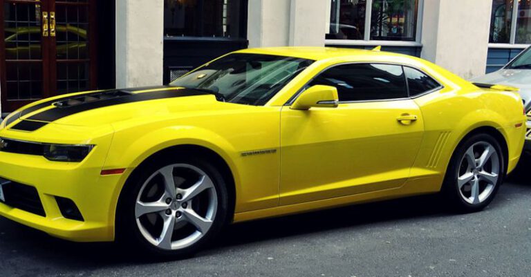 Mustang Auto - Yellow Chevroelt Camaro Parked Outside of Building