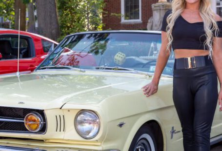 Mustang Auto - A Woman Standing Beside a Sports Car