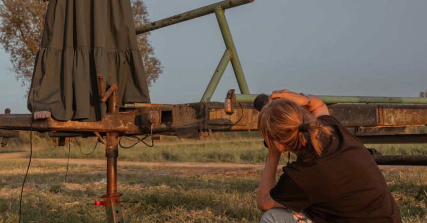 Mustang Performance Mods - A woman is kneeling on a wooden platform with a camera