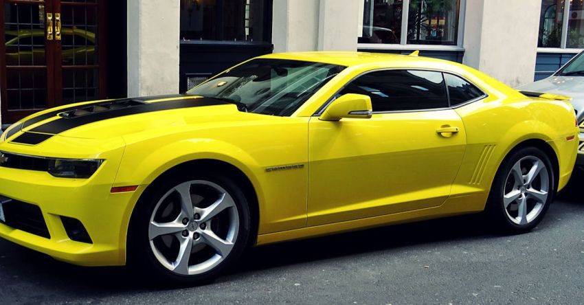 Mustang Car Reviews - Yellow Chevroelt Camaro Parked Outside of Building