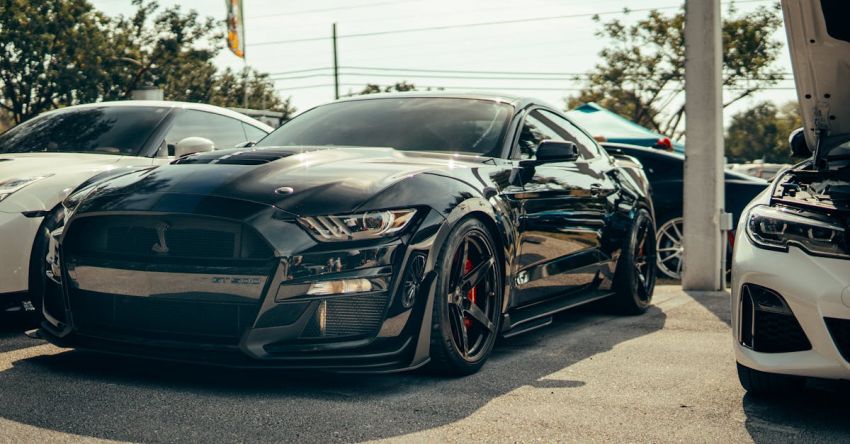 Mustang Car Reviews - A black mustang parked in front of a car showroom